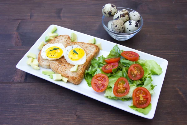 Tostadas con huevos de codorniz y ensalada sobre madera —  Fotos de Stock