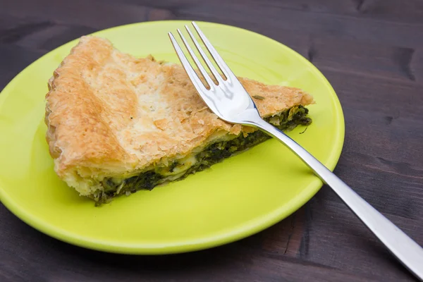 Slice of pie with spinach and cheese on wooden seen up close — Stock Photo, Image