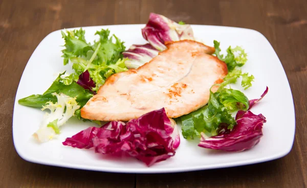 Chicken and salad on wood — Stock Photo, Image