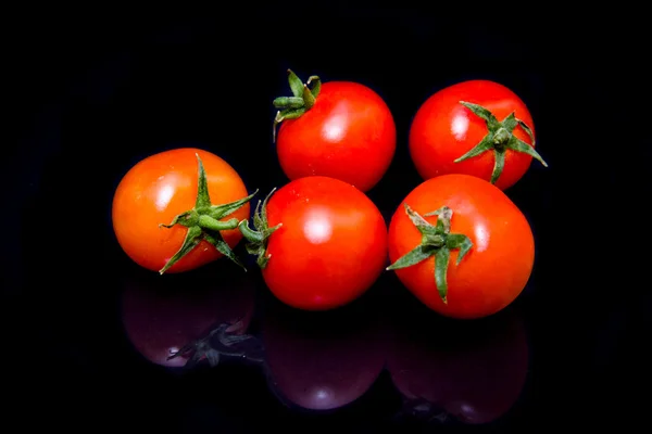 Pomodori ciliegia riflessi sul nero — Foto Stock