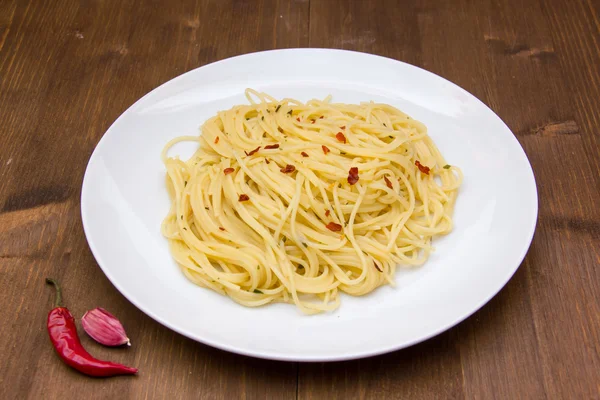 Espaguete com alho e pimentão em madeira — Fotografia de Stock