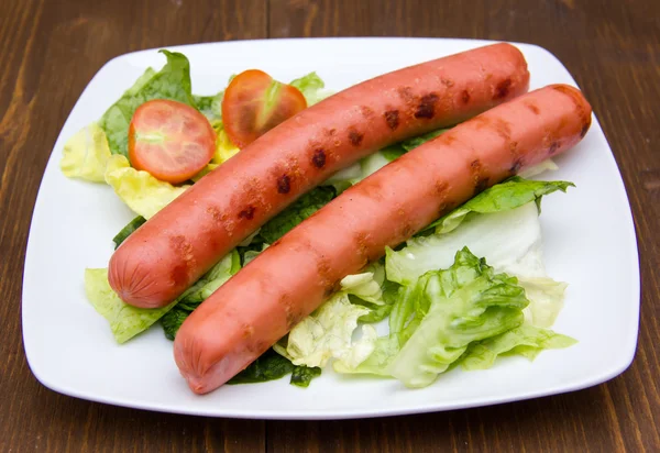 Sausages with salad on wood — Stock Photo, Image