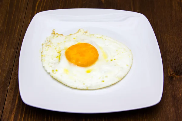 Huevo frito en plato sobre madera —  Fotos de Stock