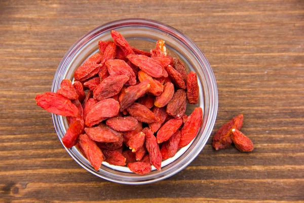 Las bayas de Goji en la escudilla a la madera de arriba —  Fotos de Stock