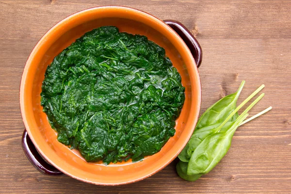 Cooked spinach to the pan on wood from above — Stock Photo, Image