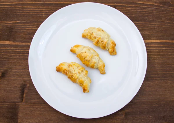 Hartige croissants met sesame op hout van bovenaf — Stockfoto