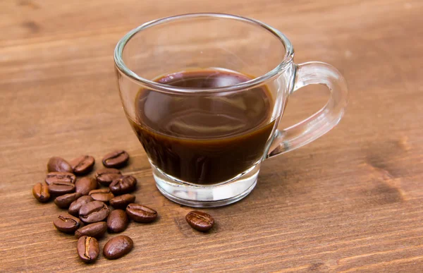 Šálek kávy a kávové boby na dřevěných úzce — Stock fotografie