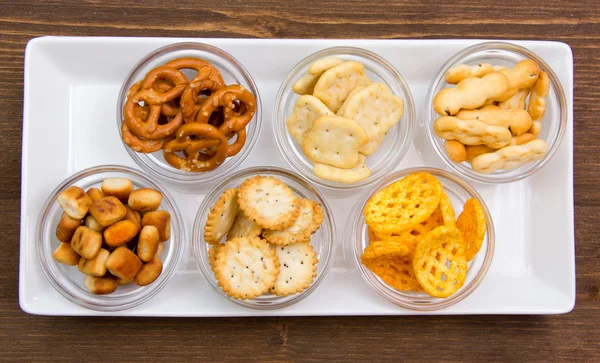 Bowls of pretzels on wooden tray on top — Stock Photo, Image
