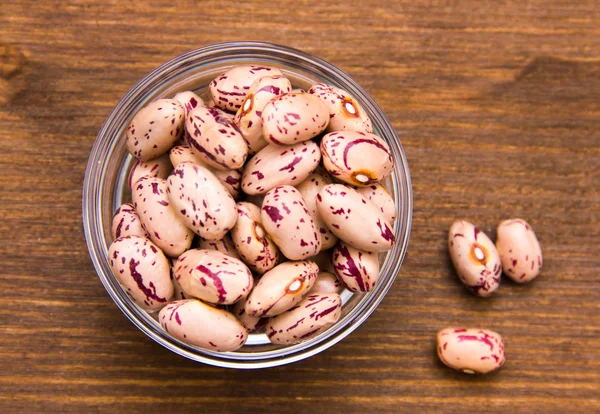 Beans inside bowl on wood from above — Stock Photo, Image