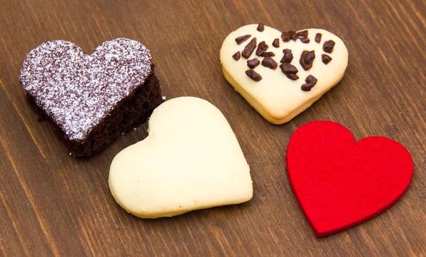 Gâteaux et biscuits en forme de cœur sur bois — Photo