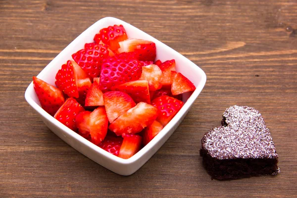 Dulce en forma de corazón y fresas en madera —  Fotos de Stock