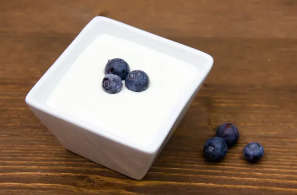 Yoghurt med blåbär på trä — Stockfoto