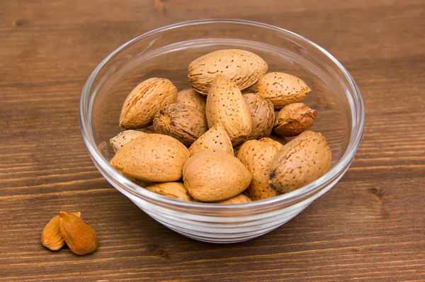 Almendras en cuenco sobre madera — Foto de Stock