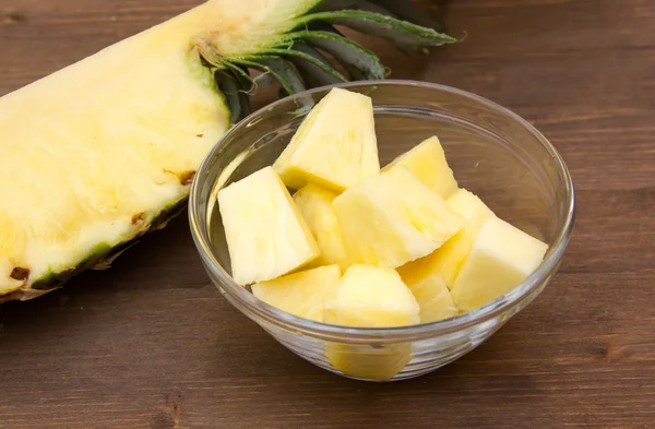 Pineapple cubes on bowl on wood — Stock Photo, Image