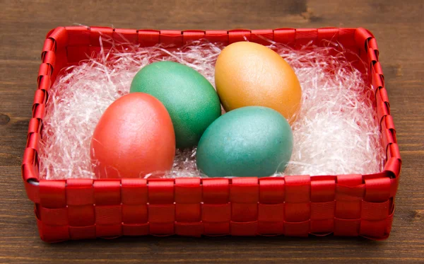 Корзина квадратная с цветными яйцами на дереве — стоковое фото