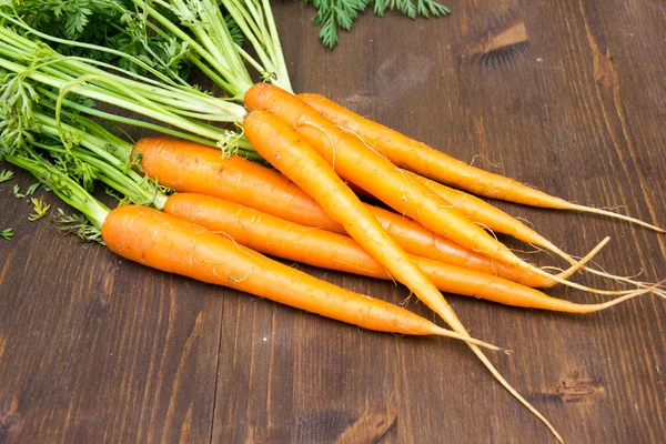 Fresh carrots on wooden seen up close — Stock Photo, Image