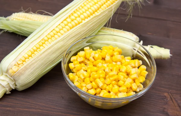 Bowl of corn cobs and wood — Stock Photo, Image