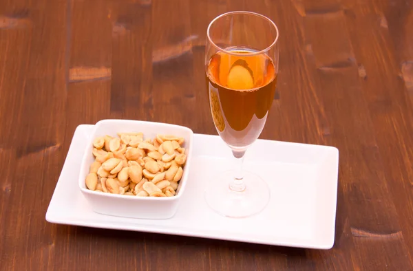 Cocktail and salted nuts on wood — Stock Photo, Image