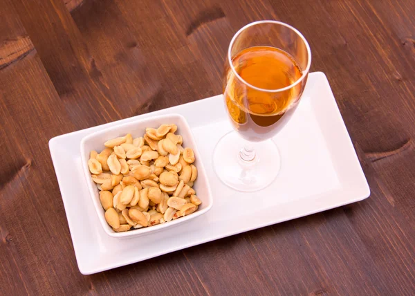 Cocktail und gesalzene Nüsse auf Holz von oben — Stockfoto