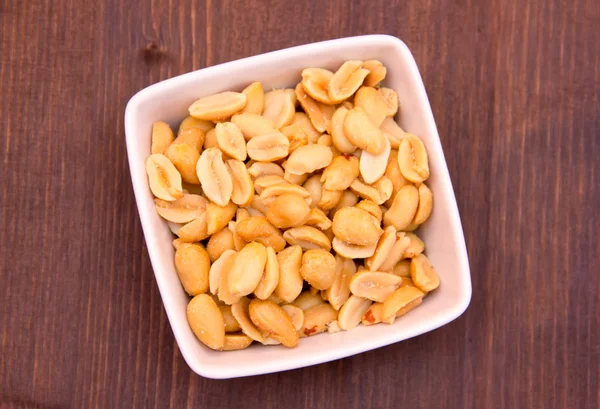 Las nueces saladas en la escudilla a la madera de arriba —  Fotos de Stock