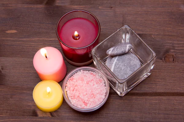 Candles and bath salts on wood from above