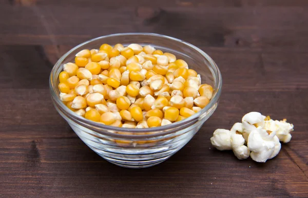 Maize grain dried with popcorn next on wood — Stock Photo, Image