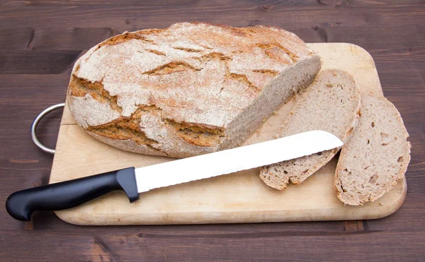 Pain sur planche à découper avec couteau sur bois — Photo