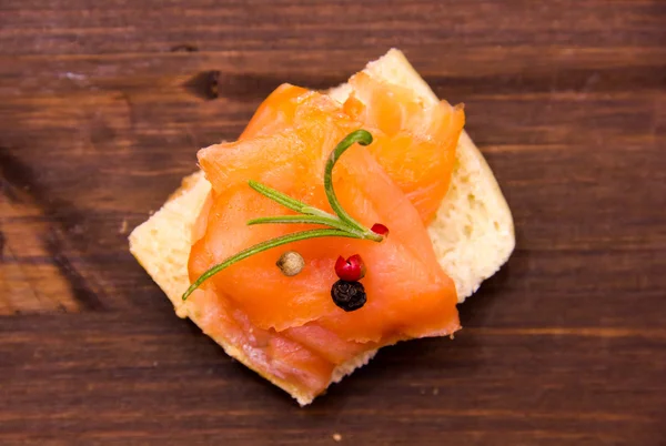 Smoked salmon on toasted bread on wood from above — Stock Photo, Image