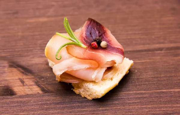 Rökt svärdfisk på rostat bröd på trä — Stockfoto