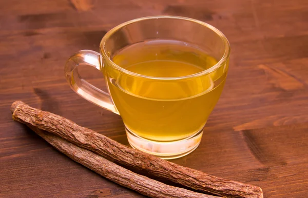 Травяная лакрица внутри чашки чая на дереве — стоковое фото