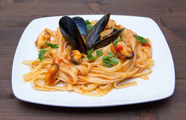 Pasta con mejillones sobre madera — Foto de Stock