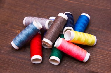 Ahşap üzerine farklı renklerde dikiş ipliği