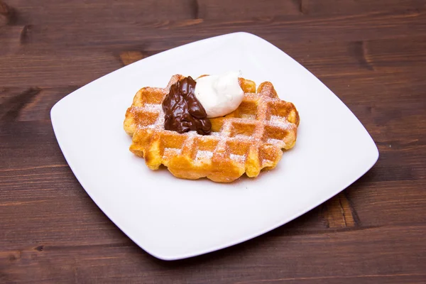 Waffles with chocolate cream on wood — Stock Photo, Image