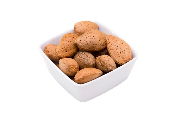 Almonds in shell of square bowl — Stock Photo, Image