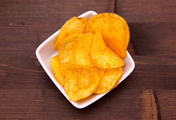 Chips paprika on square bowl on wood from above — Stock Photo, Image