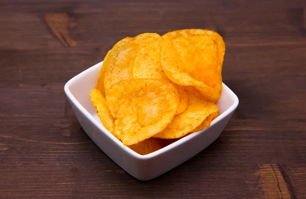 Chips Paprika auf quadratischer Schüssel auf Holz — Stockfoto