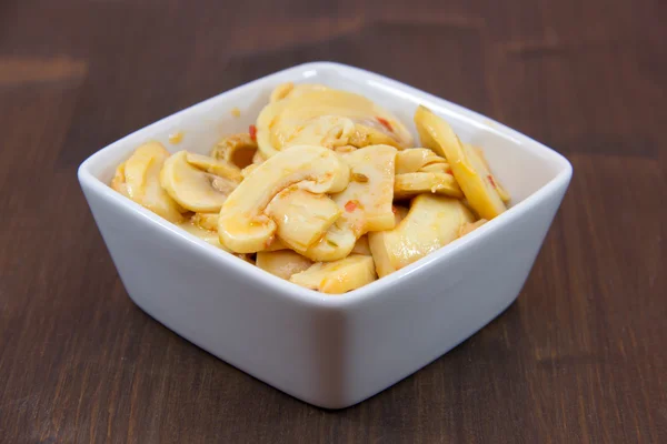 Mushrooms on spicy square bowl on wood — Stock Photo, Image