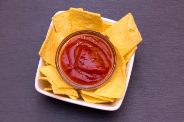 Mısır cipsi ve üst kayrak üzerinde acı sos ile kase