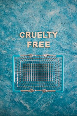 Vegan ürünleri ve hayvan hakları konsepti, Acımasızlık mavi arka planda alışveriş arabalı ücretsiz metin