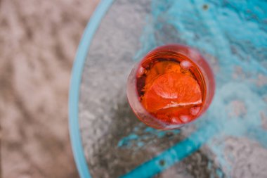 içki ve içecek serisi, şarap kadehinde portakal likörü serpiştirilmiş greyfurt dilimi açık hava masasında üst perspektiften aşağıya sığ alan derinliğinde çekilmiş.