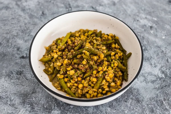 healthy plant-based food recipes concept, vegan coconut milk curry with yellow split peas green beans and onions topped with flax seeds