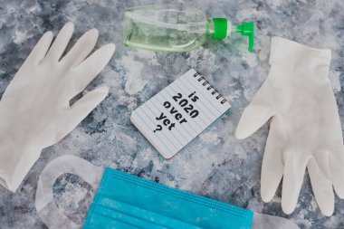 Covid-19 virüsünden sonraki yaşam. Virüs pandemik kavramsal görüntü, yazılı not. 2020 'nin üzerinde ama yüz maskesi, tek kullanımlık eldivenler ve el dezenfektanı ile çevrili.