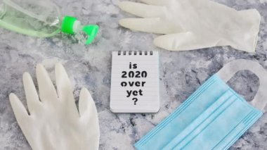 Covid-19 virüs salgınından sonraki yaşam metni 2020 'nin üzerinde ve el maskesi takılan tek kullanımlık eldivenler ve el dezenfektanı.