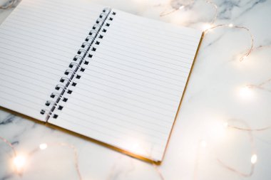 Boş defter, mermer masanın üzerinde açık sayfalar ile çevrili metin eklemek için fotokopi alanı ile çevrili.