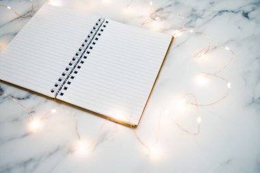 Boş defter, mermer masanın üzerinde açık sayfalar ile çevrili metin eklemek için fotokopi alanı ile çevrili.
