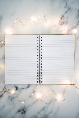 Boş defter, mermer masanın üzerinde açık sayfalar ile çevrili metin eklemek için fotokopi alanı ile çevrili.