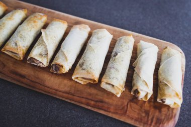 sağlıklı bitkisel yemek tarifleri konsepti, vejetaryen ev yapımı börekler ve kesilmiş tahtada kızartılmış sebzeler.