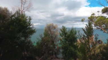 Tazmanya, Avustralya 'daki Tazmanya Sahili' nde el değmemiş vahşi bir manzarayla çevrili gökkuşağı ve fırtınalı gökyüzü.