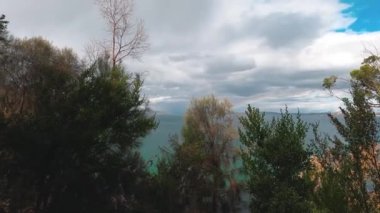 Tazmanya, Avustralya 'daki Tazmanya Sahili' nde el değmemiş vahşi bir manzarayla çevrili gökkuşağı ve fırtınalı gökyüzü.