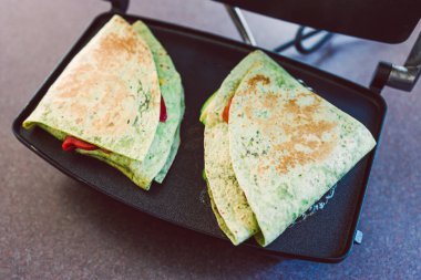 Sağlıklı bitkisel yemek tarifleri konsepti, viral katmanlı tortilla paketinin vejetaryen versiyonu kırmızı biberli rendelenmiş sütsüz peynir avokadosu ve ızgarada yeniden kızartılmış fasulye.